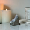 Decorative stone on a surface with a candle and another object in the background