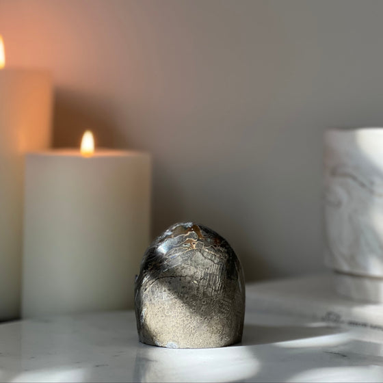 Decorative stone on a surface with a candle in the background