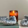 Geode crystals on a book with an amber candle in the background