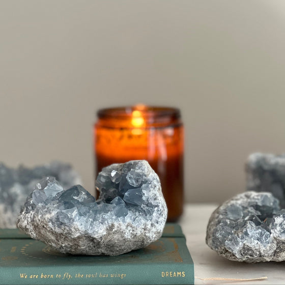 Geode crystals on a book with an amber candle in the background
