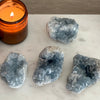 Geode crystals and a lit candle on a marble surface