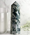 Moss Agate Tower with candle and flowers in the background.