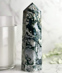  Moss Agate Tower with candle and flowers in the background.