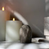 Rear view of crystal stone on marble stand with candles in the background