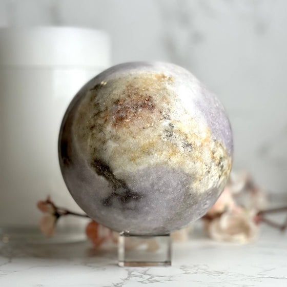 Pink Amethyst decorative sphere on a stand with a blurred background