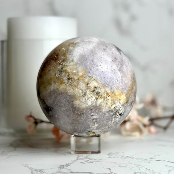 Pink Amethyst decorative sphere on a stand with a blurred background