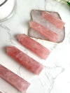 Rose Quartz points from a top view on a marble background.