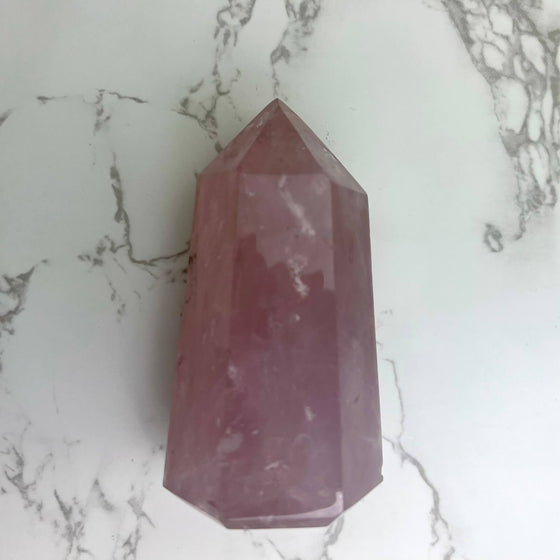 Rose Quartz Crystal showcased on a marble background