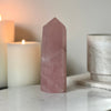 Rose quartz crystal featuring candle and book in background