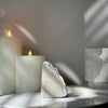 Decorative stone on a surface with candles and a blurred background